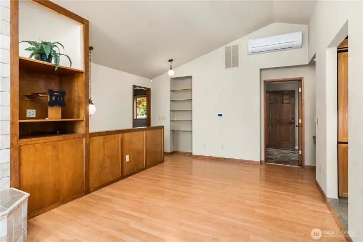 The other side of the living room has a TV mount with a lighted display area above and wood storage below behind the hidden door. Wood stove is on the left. Another ductless mini, a small desk area and shelving. THis was set up with recliners for TV viewing.