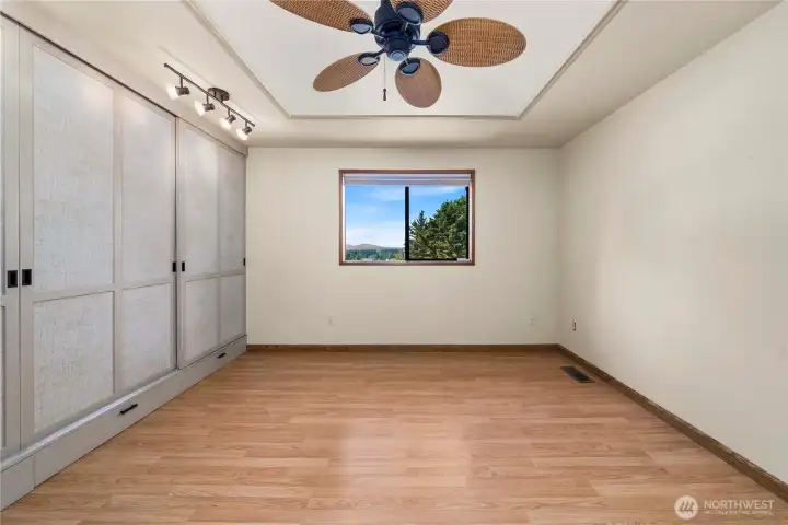 Primary bedroom with custom made sliding closet doors and shoe drawers beneath.