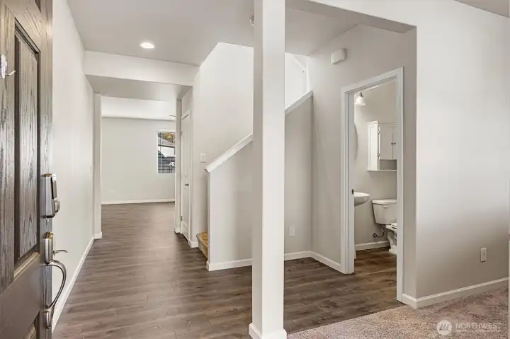 Welcoming entry showcases laminate floors, a useful flex room, and a convenient main-level guest bath
