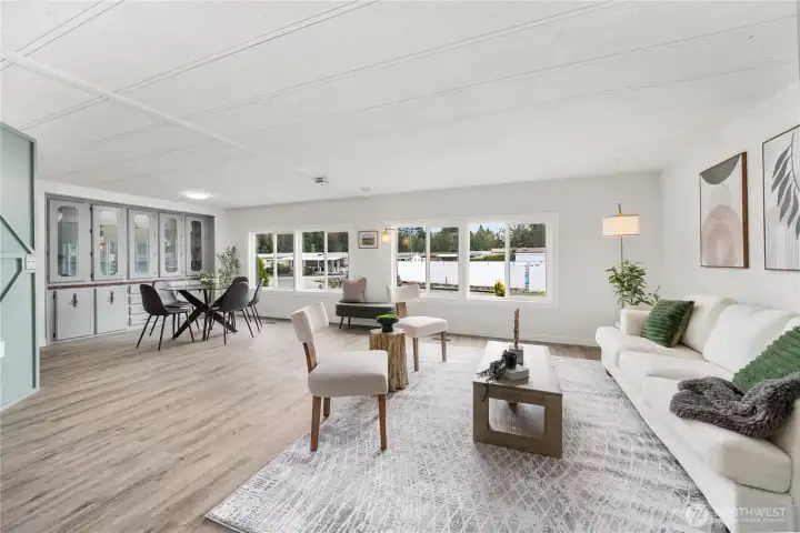 Light-filled open living area features NEW luxury vinyl plank flooring, NEW double-paned vinyl windows, and seamless flow into the dining space.