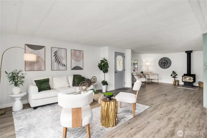 Spacious living room flows seamlessly into the adjacent den featuring a cozy wood-burning stove—perfect for relaxing or creating a flexible bonus space.