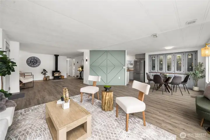Open-concept design connects the living and dining areas effortlessly, highlighted by a stylish green accent wall that adds warmth and character to the space.