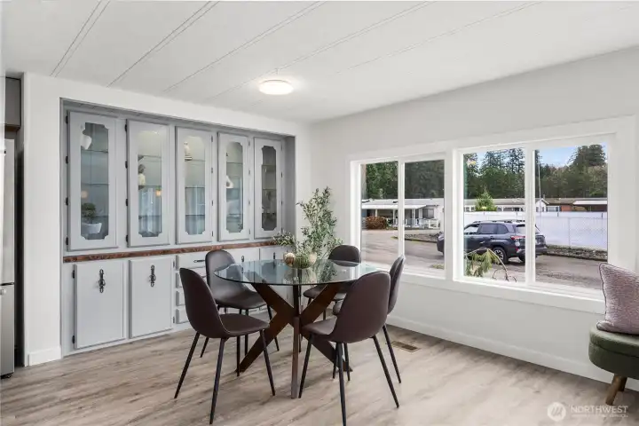Bright dining area with NEW LED lighting, lit built-in credenza and expansive windows creates a cheerful space for everyday meals or hosting guests.