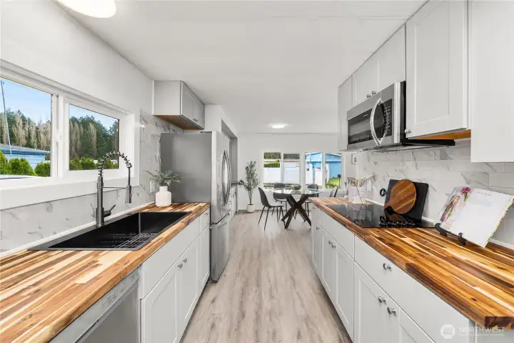 Updated kitchen shines with NEW butcher block countertops, NEW Shaker cabinetry, NEW backsplash and a spacious layout designed for both cooking and entertaining.
