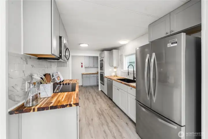 NEW Stainless steel appliances and generous counter space enhance this functional, light-filled kitchen.