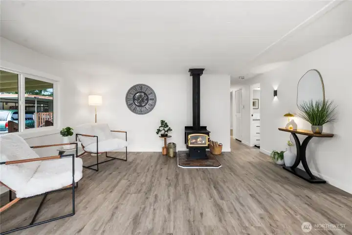 Versatile den with a cozy wood-burning stove & motion-sensored sconces create the perfect retreat for relaxing, reading, or enjoying a quiet evening at home.