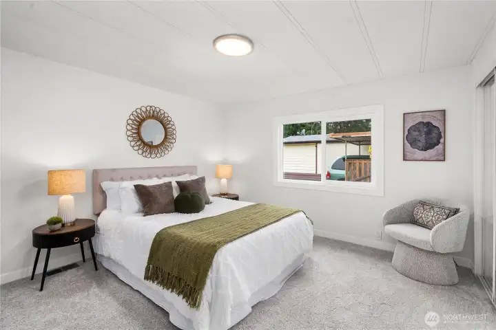 Bright and inviting bedroom features soft natural light and a comfortable layout ideal for rest and relaxation.