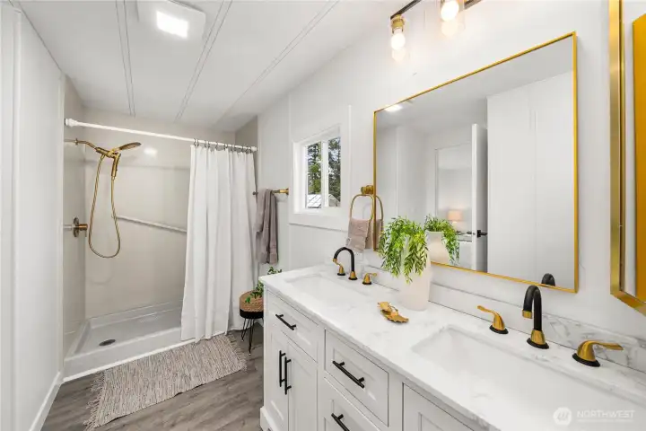 Updated bathroom showcases a NEW modern double vanity, NEW stylish fixtures, NEW LVP flooring, NEW Mirrors, NEW lighting and a refurbished walk-in shower for everyday convenience.