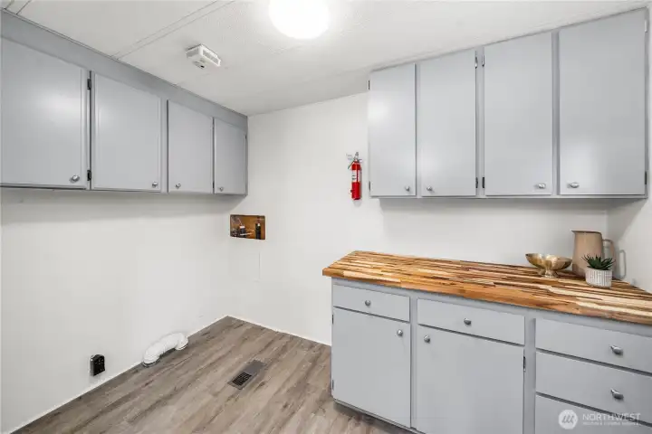 Spacious utility room offers NEW butcher block counters, freshly painted cabinetry w/new hardware & abundant counter space—ideal for storage, hobbies, or laundry organization. NEW hot water heater!