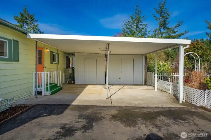 Covered side-by-side carport w/ 2 sheds offers convenient, protected parking & storage with easy access to the home.