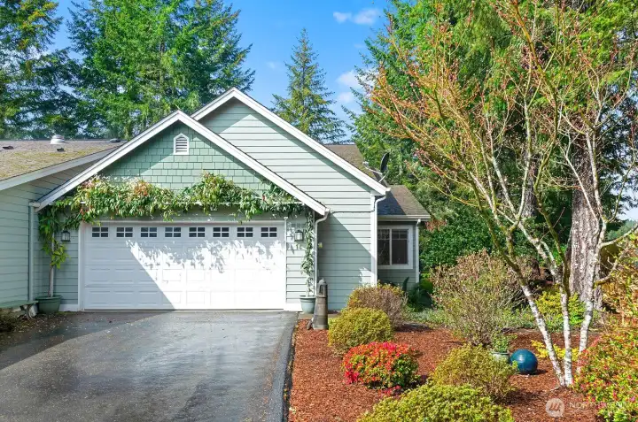 Attractive 2 car garage framed by a mature clematis vine complimented by well kept side yard