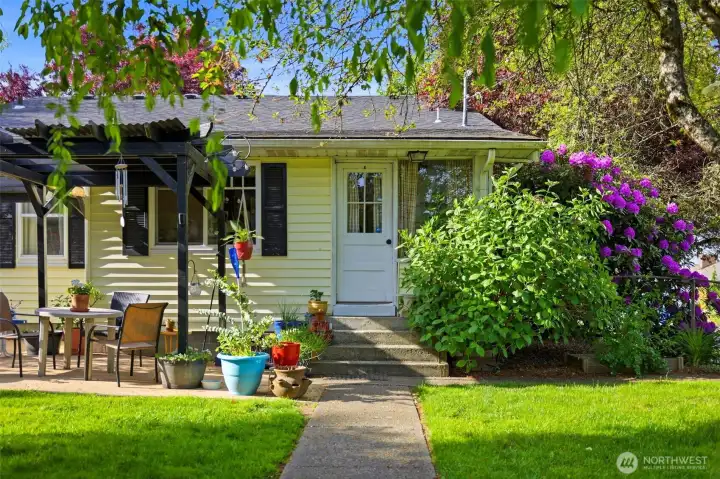 Dreamy backyard with an outdoor patio and plenty of grass to enjoy.