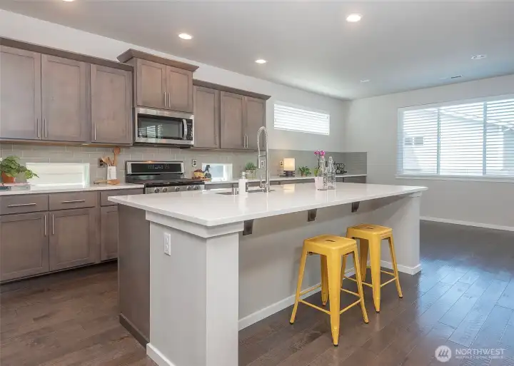 Quartz countertops and richly finished cabinetry extend into the dining area, forming a custom built-in banquet that enhances both the design and functionality of the space.