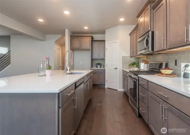 The large kitchen island serves as the centerpiece of the home, offering both a striking focal point and a highly functional space for gathering, entertaining, and everyday living.