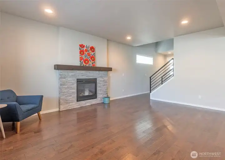 A beautiful gas fireplace anchors the main living area, while refined wrought-iron staircase detailing adds a timeless architectural touch. The home is thoughtfully designed with strategically placed windows that flood the interior with natural light, enhancing the open and inviting feel throughout.