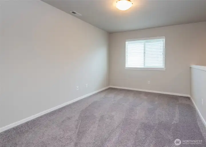 Just outside the primary suite, a spacious loft offers flexible living space ideal for a home office, study area, or secondary lounge.