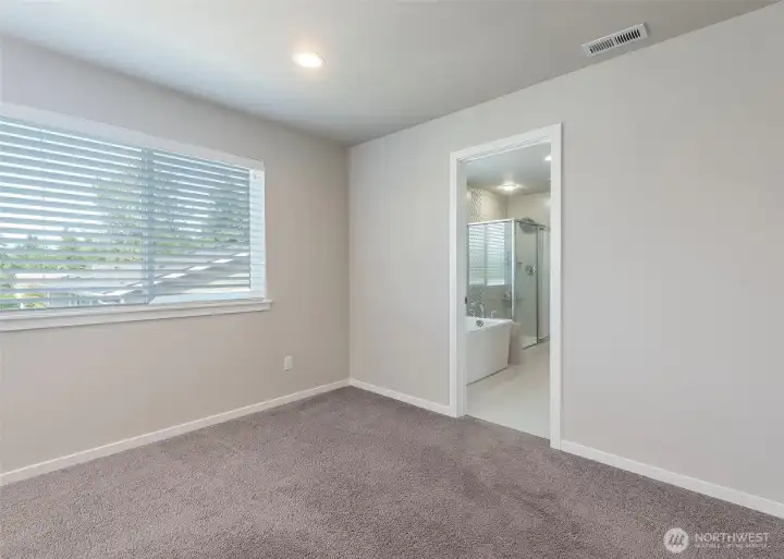 Light-filled and inviting, the spacious primary suite offers a peaceful retreat complete with a generous walk-in closet.
