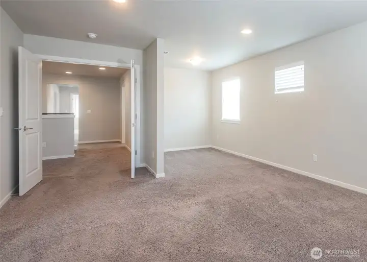 Double doors welcome you into the impressive primary suite, where a spacious sitting area creates a private retreat perfect for relaxing, reading, or unwinding at the end of the day.