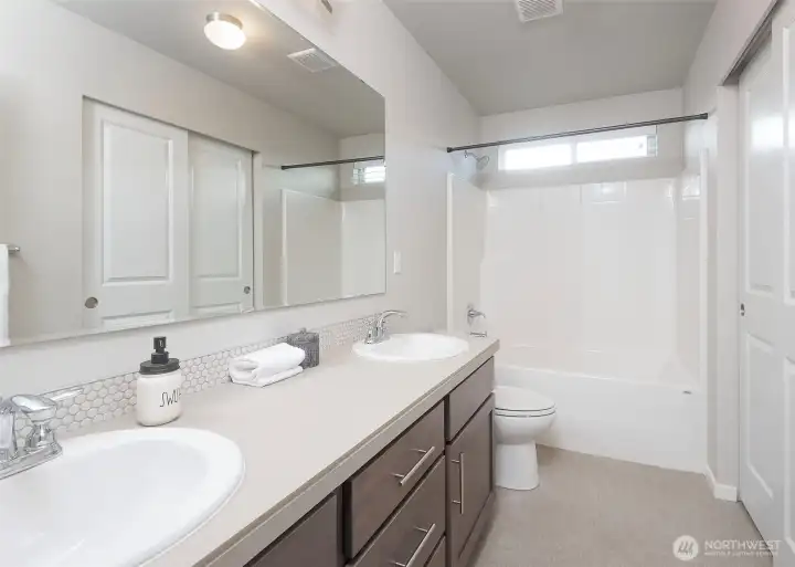 The well-designed hallway bedroom offers generous proportions and is complemented by dual sinks, providing enhanced convenience and versatility for guests or shared use.