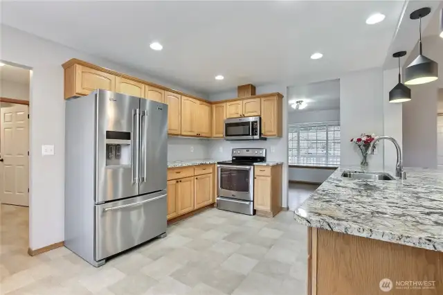 Open kitchen with stainless appliances.