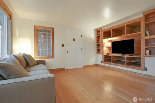 Main (South) home upper level living room with hardwood floors, bump out for entertainment center, woodstove and western exposure.