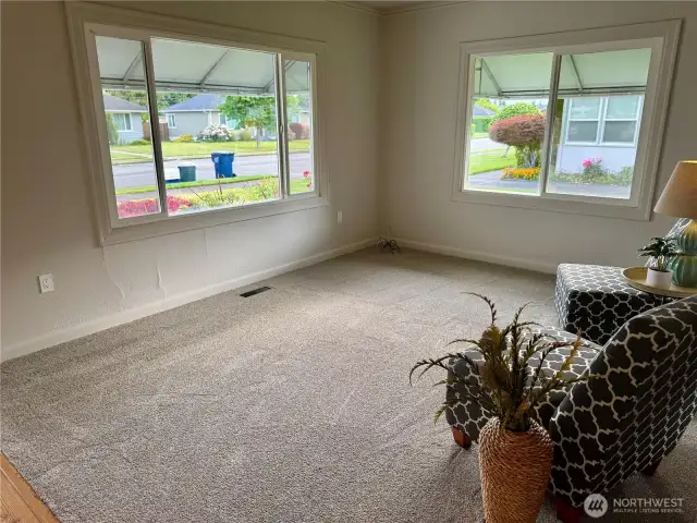 Living room with double windows, new carpet and all new paint.