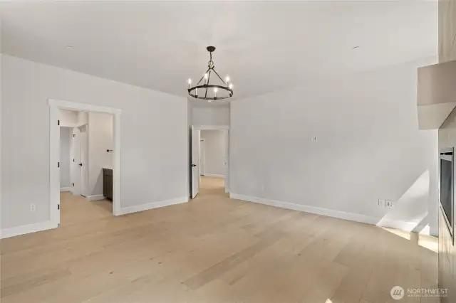 Primary bedroom with upgraded flooring and elegant chandler.