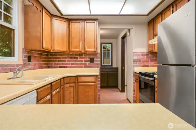 A tidy kitchen space with back door + mudroom and laundry room just beyond.