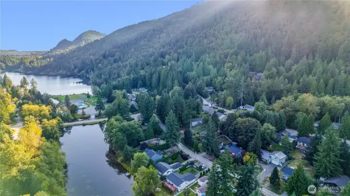 Perfectly located with nearby lake and amenity access (in this photo, the home is second furthest from the right with the top floor, natural wood deck)