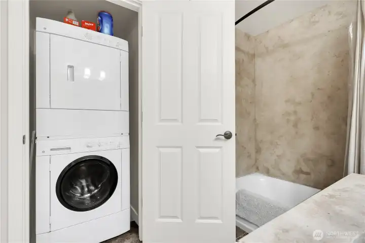 Big stacker washer and dryer in large bathroom closet.