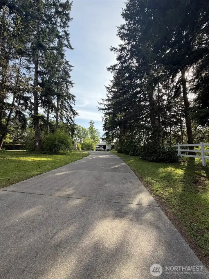 Paved driveway with established landscaping welcomes you home