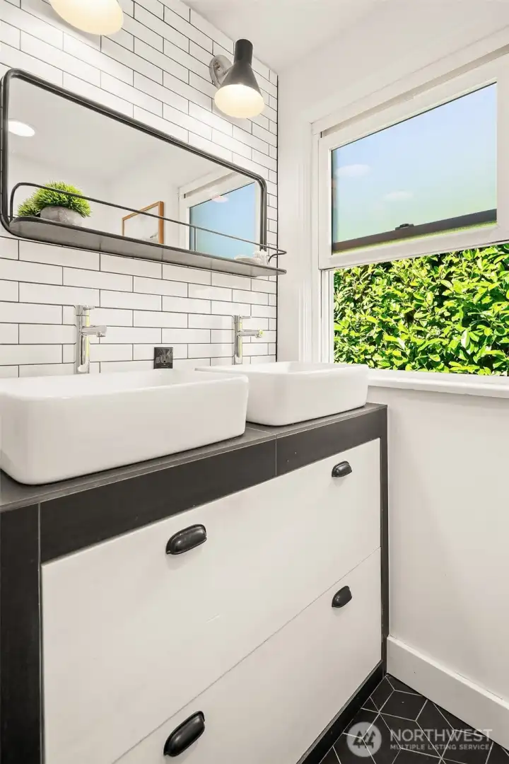 Main level bath with double sinks and walk-in shower.