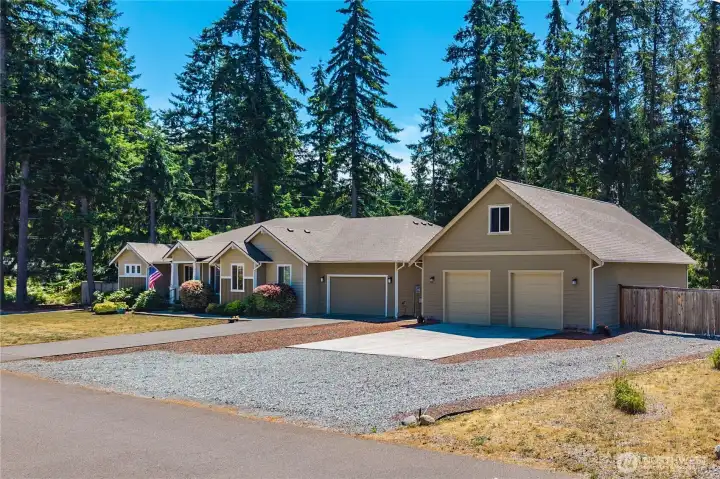 Spacious Graham property featuring a large rambler, detached shop, gravel parking area, and private evergreen backdrop. Spacious Graham property featuring a large rambler, detached shop, gravel parking area, and private evergreen backdrop.