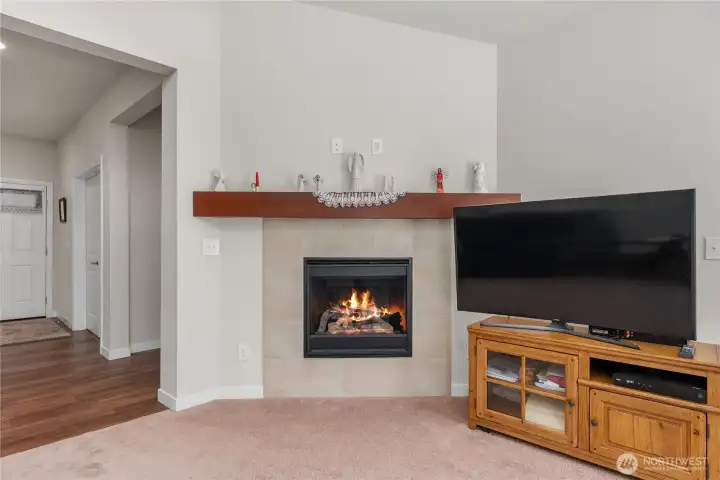 Gas fireplace with tile surround and wood mantel, creating a cozy focal point in the spacious main living room. Gas fireplace with tile surround and wood mantel, creating a cozy focal point in the spacious main living room.