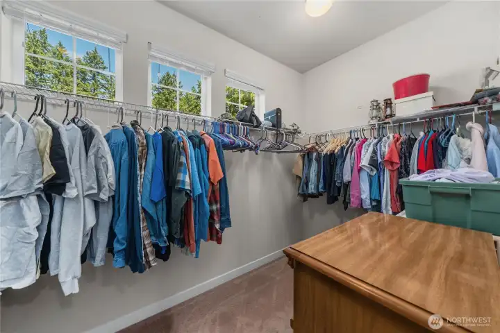 Large walk-in closet with multiple windows, built-in hanging space, and room for additional storage or organization. Large walk-in closet with multiple windows, built-in hanging space, and room for additional storage or organization.