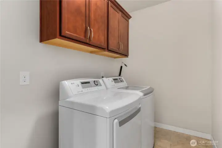 Laundry room with washer and dryer area, cabinet storage, and functional space for everyday household needs. Laundry room with washer and dryer area, cabinet storage, and functional space for everyday household needs.