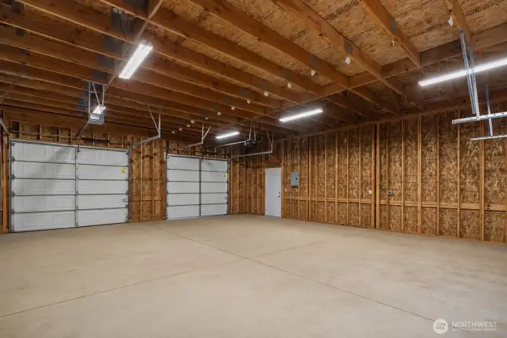 Large shop interior offering flexible work space, multiple garage door access points, overhead lighting, and excellent storage potential. Large shop interior offering flexible work space, multiple garage door access points, overhead lighting, and excellent storage potential.