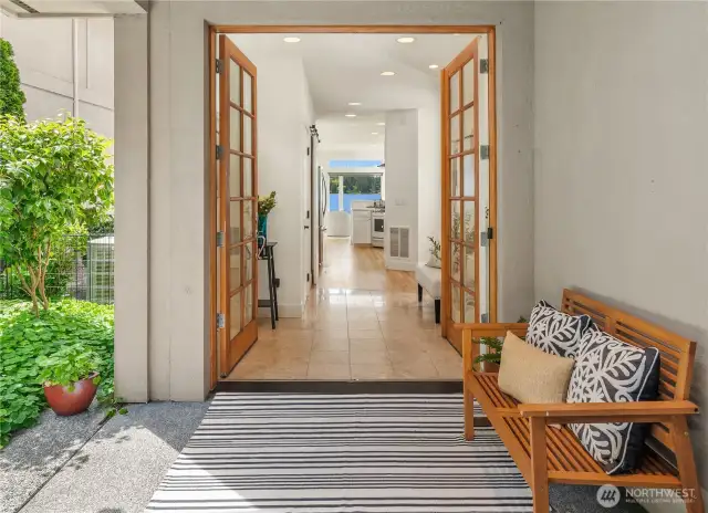 Enter the home through a covered entryway, garden on left with path to waterfront patio.