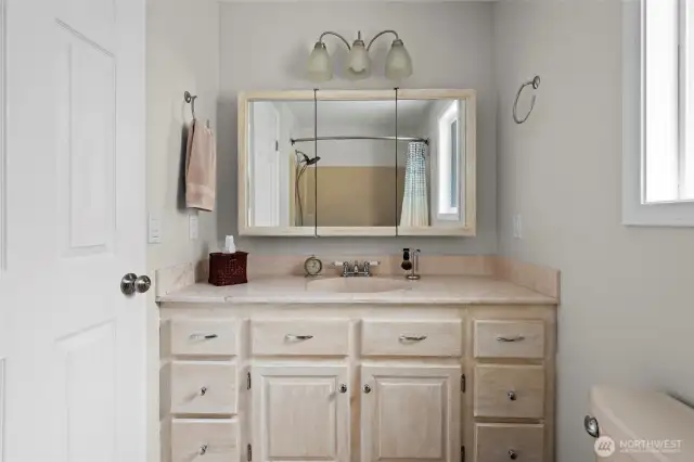 Full bathroom off primary bedroom, solid wood cabinets and solid surface countertop.