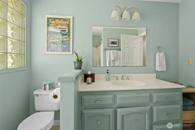 Beautiful guest full bathroom, with tiled floor, glass block exterior wall, solid wood cabinets and solid surface countertop.
