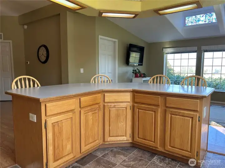 Horseshoe bar separates the kitchen and family room.  Door in the center leads to the utility room with half bath.