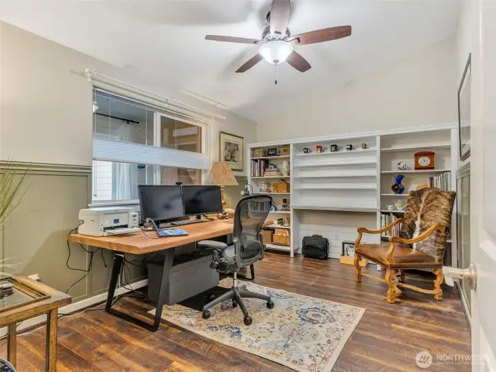 Bedroom #1 currently being used as an office space with built in cabinetry and wainscoting surround.