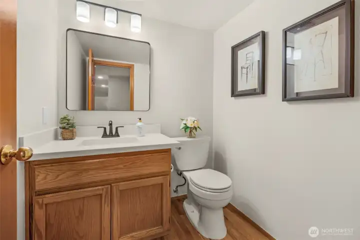 Main floor powder room with new quartz counter, mirror, lighting and refinished hardwood floor