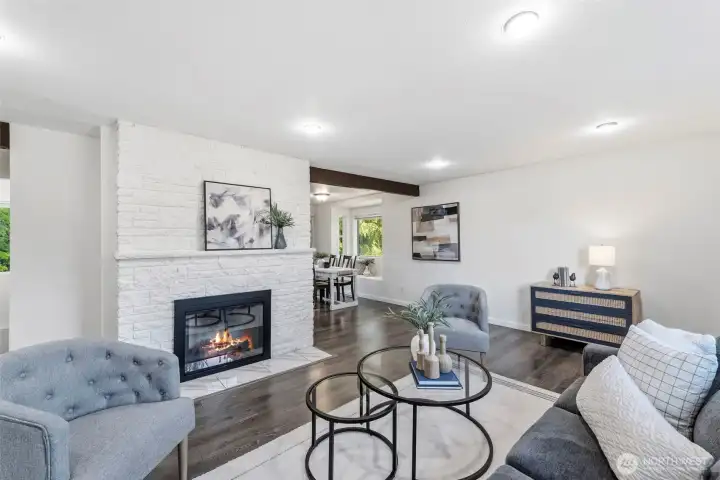 Main floor living room with wood burning fireplace and exposed beams.