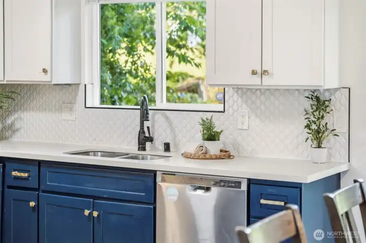 A large window over the kitchen sink that looks out back over the oversized back yard.