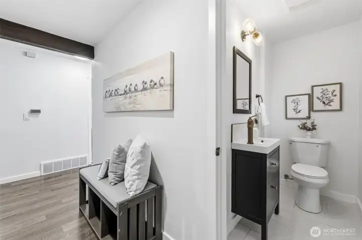 The half bathroom is located off the hallway near the living room.