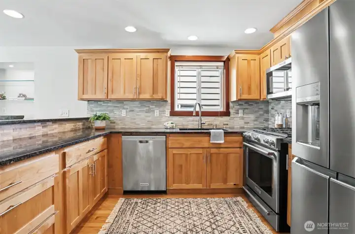 The heart of the home. Beautifully updated kitchen, stainless appliances, granite counters, warm wood cabinets & ample prep space!