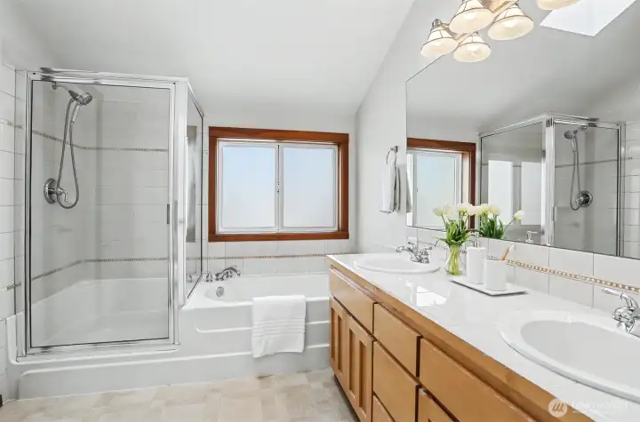 En suite, with separate shower & jetted tub. Neutral white tile, clean & always classic.