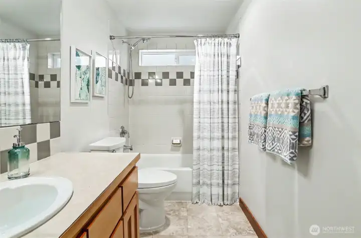 Full bath on first floor, situated between the two bedrooms.