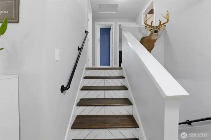 Stylish stairs to upper level, with three bedrooms, primary bath and hall bath.